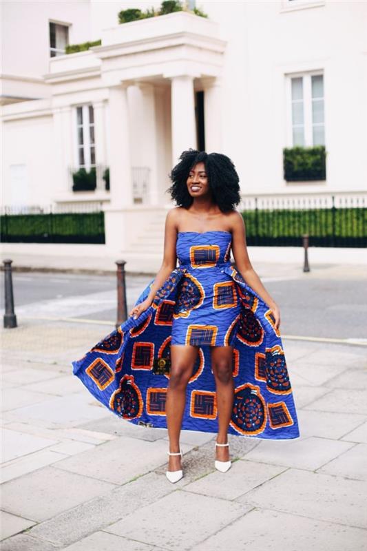 فستان أفريقي حديث بدون أكتاف ، مع قطار مهيب من نفس القماش بنقوش برتقالية وزرقاء على خلفية زرقاء ملكية