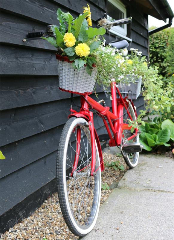 vintage röd cykel som används som ställ för blomkrukor, lekhus i trä, kreativ trädgårdsinredning