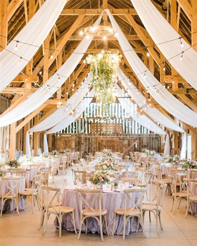 biele záclony na ozdobenie zalesnenej strechy odhalenými trámami, elegantné kvetinové stoly so svetlo fialovými obrusmi