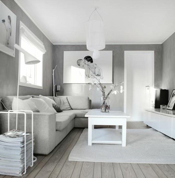 grå väggar, vitt soffbord i trä, grå hörnsoffa, trägolv, hängande foton, grå färgscheman