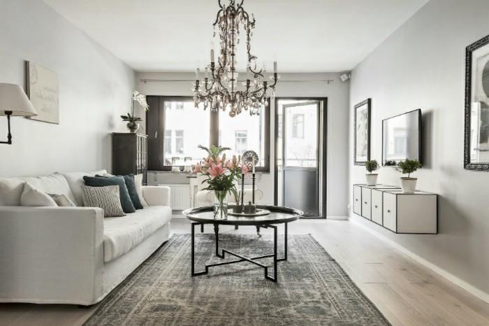grå vardagsrumsmöbler, hängande ljuskrona, vit soffa, svart metall soffbord