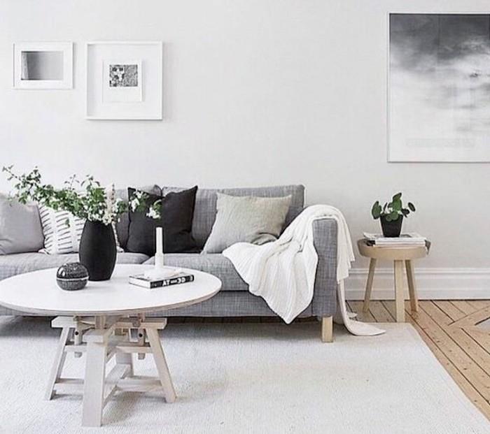 vit matta, hängande inramad konst, grå soffa, grå och svart, kuddar, soffbord i trä, fina vardagsrum