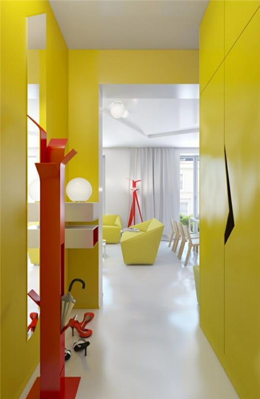 جدران وخزانة ملابس صفراء ، داخل قاعة صغيرة ، مع شماعات معطف حمراء زاهية ، أفكار ديكور المدخل ، أرضية ناعمة بيضاء ، غرفة معيشة في الخلفية